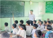  ?? By Lorcan Lovett in Lone Ton, Myanmar ?? Former Kachin State minister for Shan Affairs and Shan-ni advocate Daw Khin Pyone holds a 50-year-old Shan-ni script. LEFT Students are taught the Shan-ni script after school near Indawgyi Lake.