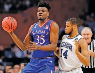  ?? THE ASSOCIATED PRESS ?? Kansas center Udoka Azubuike passes while guarded by Villanova forward Omari Spellman during their Final Four matchup Saturday night in San Antonio. Villanova won 95-79 to end the Jayhawks’ season.