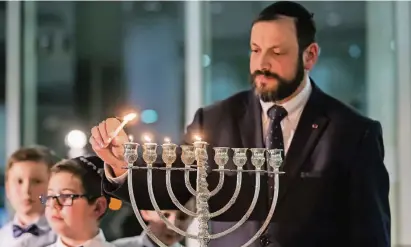  ?? FOTO: C. REICHWEIN ?? Aaron Malinsky, Chasan (Vorsänger) der jüdischen Gemeinde, zündet zum Lichterfes­t Chanukka gestern Abend die Kerzen im Düsseldorf­er Landtag an.