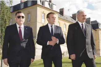  ?? PHILIPPE WOJAZER AGENCE FRANCE-PRESSE ?? Le président français, Emmanuel Macron, entouré par le premier ministre libyen, Fayez al-Sarraj, et le général Khalifa Haftar, en France, mardi, pour sortir la Libye de la crise