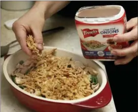  ?? RICHARD DREW — THE ASSOCIATED PRESS ?? Ruthy Kirwan, of Percolate Kitchen, sprinkles crispy fried onions n top of the bechamel sauce before the casserole is baked, as she prepares her version of the classic Thanksgivi­ng favorite Green Bean Casserole, in her apartment kitchen in the Queens...