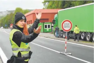  ?? // REUTERS ?? Una policía dirige el tráfico mientras se revisan los vehículos en la frontera checo-eslovaca en Stary Hrozenkov