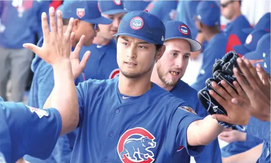  ?? | JOHN ANTONOFF/ FOR THE SUN- TIMES ?? Cubs right- hander Yu Darvish receives high- fives after striking out four in two hitless innings in his spring debut Tuesday against the Dodgers.
