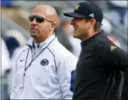  ??  ?? Michigan head coach Jim Harbaugh, right, chats with Penn State head coach James Franklin before a game in State College.