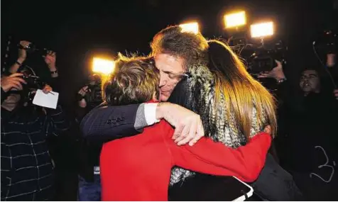  ?? AFP ?? Man of letters Romanian football player Popescu (centre) hugs his family after he was released from the Jilava penitentia­ry near Bucharest on November 4. His sentence was reduced largely due to four books about the beautiful game he penned while in jail.