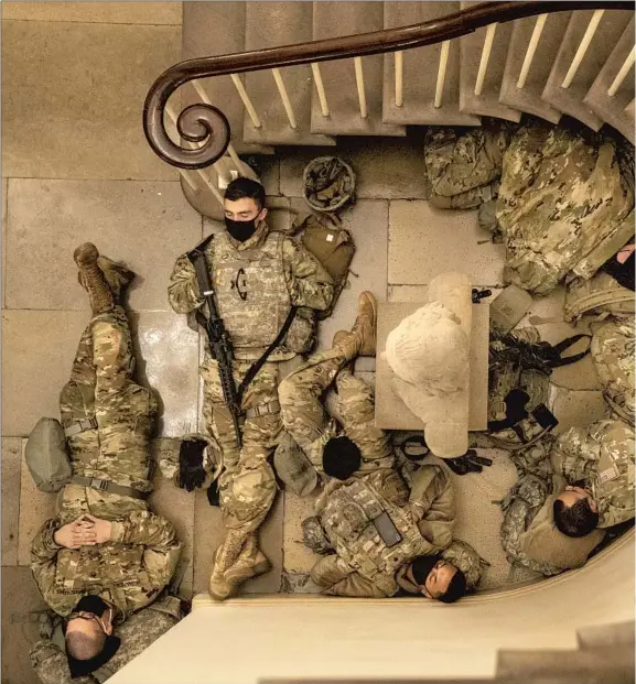  ?? NATIONAL GUARD ?? troops stationed in the U.S. Capitol sleep wherever they can find space Wednesday. Defense Department officials said that as many as 20,000 National Guard troops mobilized from multiple states could arrive in Washington before the Jan. 20 inaugurati­on.