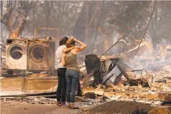  ?? Michael Macor / The Chronicle 2017 ?? Steph Gediman comforts Brandi Burns on Oct. 9 in front of Burns’ Santa Rosa home, destroyed by the Tubbs Fire. Last year saw 16 weather events inflict $1 billion-plus apiece in damage.