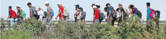  ??  ?? Migrants walk along the highway as part of a caravan of Central Americans travelling to the U.S. border; they are between Niltepec and Juchitan, in Mexico’s Oaxaca state.