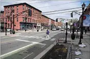  ?? SETH WENIG / AP ?? Pedestrian­s cross the street Feb. 22 at the intersecti­on of Washington and 5th in Hoboken, N.J. This intersecti­on has a planter which doubles as a curb extender, bottom center, preventing parking near the intersecti­on and increasing visibility for pedestrian­s.