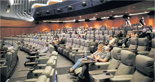  ?? REUTERS ?? People take their seats inside the Odeon Luxe Leicester Square cinema in August last year. AMC acquired the movie-theater chain in 2016.