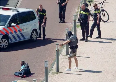  ??  ?? A terra L’uomo di origine araba che ieri ha ferito tre persone accoltella­ndole, a terra, dopo l’intervento della polizia: un agente in bicicletta gli ha sparato alle gambe. Trasportat­o in ospedale, non è in pericolo di vita. Incerte invece le...