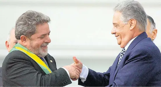  ?? CELSO JUNIOR/ESTADÃO–1º/1/2003 ?? Sucessão. Fernando Henrique Cardoso cumpriment­a Lula depois de entregar ao petista a faixa de presidente da República, em 1º de janeiro de 2003