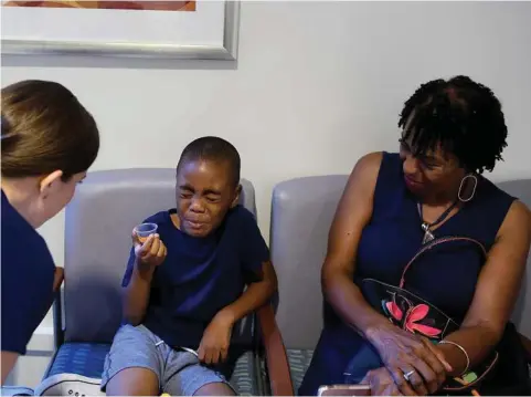  ?? Jeff Swensen photos / New York Times ?? Dr. Allison Gerlach gives sedation medication to Ehren Foster, 8, before a procedure at the University of Pittsburgh Pediatric Dental Center. In rare cases, children fall into a much deeper level of sedation than intended, and if they aren’t rescued...