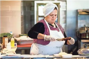  ?? COMMERCIAL APPEAL ?? Global Cafe Syrian chef Fayha Sakkan prepares a chicken kebab in the 2,500-square-foot restaurant inside Crosstown Concourse. MARK WEBER/THE