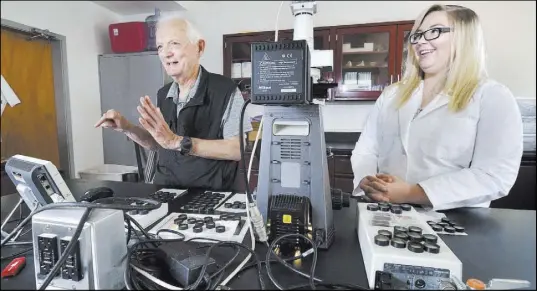  ?? Bill Hughes Las Vegas Review-Journal ?? Eugene Smith, left, professor emeritus of geology at UNLV, with senior geology major Shelby Fitch in the cryptoteph­ra lab. By tracing the microscopi­c glass shards back to the eruptions that created them, UNLV’s cryptoteph­ra lab can provide precise...