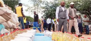  ??  ?? Matabelela­nd North Provincial Affairs Minister Richard Moyo (wearing cap) and Senate Chief Siansali tour flood-hit areas in Binga yesterday.Foreground are some of the food items donated to the flood victims. Picture: Eliah Saushoma