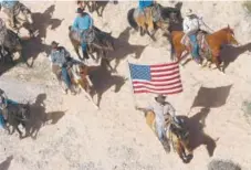  ?? Jason Bean, Las Vegas Review-journal ?? In this April 12, 2014, file photo, the Bundy family and their supporters fly the American flag as their cattle are released by the Bureau of Land Management back onto public land outside of Bunkervill­e, Nev.