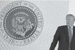  ?? JONATHAN ERNST • REUTERS ?? U.S. President Donald Trump takes the stage next to an altered presidenti­al seal prior to a speech at Turning Point USA's Teen Student Action Summit in Washington on Tuesday.