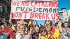  ?? FOTO: DPA ?? Demonstran­ten beim Protest in Barcelona gegen die Pläne der Regionalre­gierung Katalonien zur Abspaltung von Spanien. „Wir sind Katalanen. Puigdemont wird uns nicht zerbrechen“, steht auf dem Schild.