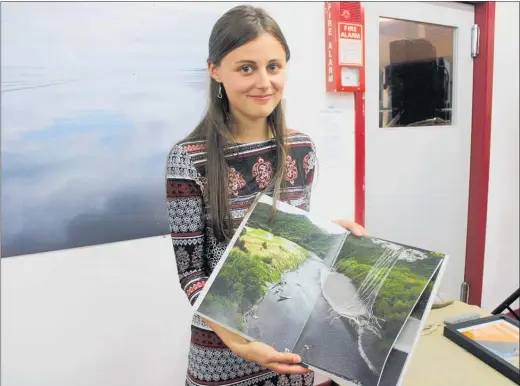  ??  ?? Woodville Art and History Artist in Residence Martina Havlova with her book of photos portraying her view of the Manawatu¯ River and its people.