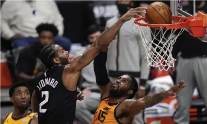  ?? Photograph: Mark J Terrill/AP ?? Kawhi Leonard dunks over Utah Jazz center Derrick Favors.