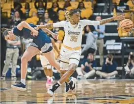  ?? KENNETH K. LAM/BALTIMORE SUN ?? Towson’s Anissa Rivera, right, steals the ball from Monmouth’s Lovin Marsicano during Sunday’s CAA Tournament final at SECU Arena.