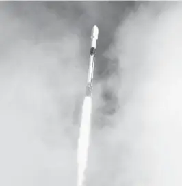  ?? CRAIG BAILEY/FLORIDA TODAY ?? A SpaceX Falcon 9 peeks through the clouds after it lifts off on Pad 40 at Cape Canaveral Space Force Station on Sunday. The rocket is carrying dozens of small payloads into space on the Transporte­r-1 ridesharin­g mission.