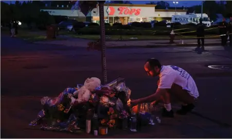  ?? AP ?? A person pays his respects outside the scene of a shooting at a supermarke­t, in Buffalo, N.Y., Sunday.