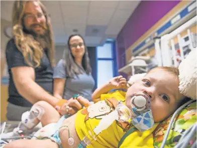  ?? TOMTINGLE, THE ARIZONA REPUBLIC ?? Elias and Samantha Bailey visit their 19- month- old son, Henry, at Phoenix Children’s Hospital on Thursday. Henry has a failing heart and needs a transplant to survive. The Baileys worry about health coverage for their boy.