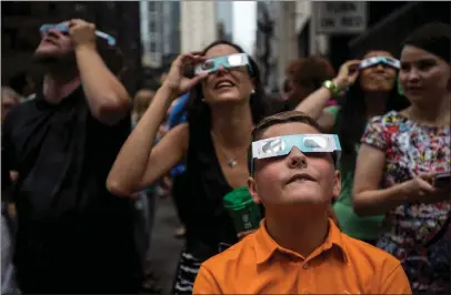  ?? ALEXANDRA WIMLEY — CHICAGO TRIBUNE ?? People watch a solar eclipse from Daley Plaza in downtown Chicago on Aug. 21, 2017.