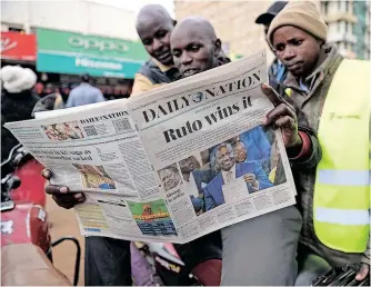  ?? AFP ?? MOTORCYCLE riders read the ‘Daily Nation’, a local daily newspaper, with a headline reporting the election of Kenya’s fifth President elect William Ruto, in Eldoret on August 16, 2022. |