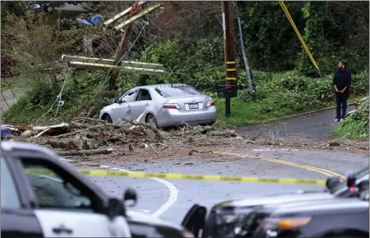  ?? JANE TYSKA — STAFF PHOTOGRAPH­ER ?? A downed tree and power pole block Moraga Avenue near Harbord Drive in Oakland on Tuesday. The latest atmospheri­c river brought the Bay Area ferocious winds, power outages, downed trees and more rain.