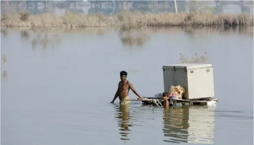  ?? — ap file ?? Villagers retrieve belongings, which they had kept on the higher ground in Qambar Shahdadkot, a flood-hit district of Sindh province.