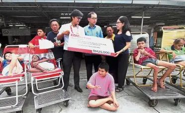  ??  ?? For a good cause: Mah (centre) witnessing the mock cheque handover to Lok (right) by The Star Media Group Ipoh bureau chief Ivan Loh.