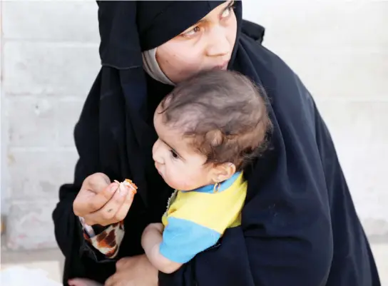  ??  ?? A woman feeds her baby after fleeing Mosul's Old City, the last district in the hands of Daesh militants in western Mosul, on Saturday. (Reuters)