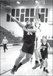  ?? NWA Democrat-Gazette/DAVID GOTTSCHALK ?? Prairie Grove’s Demarkus Cooper (24) goes for a layup around Rogers High’s Garrett Dake on Thursday during the Panther Holiday Classic in Siloam Springs.