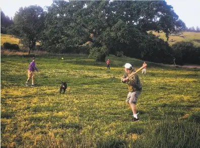  ?? John Shea / The Chronicle ?? Eddie Joe Chavez bats against Neal Chavez as Buck Chavez and Nicole Chavez play the field in San Geronimo.