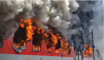  ?? — PTI ?? Smoke billows out of the two bogies of Andhra Pradesh AC Superfast Express which caught fire near a station in Gwalior on Monday morning. Around 150 passengers, including 39 deputy collectors, had a narrow escape when the train caught fire near Birla...