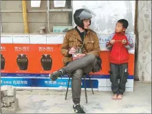  ??  ?? Top: Dane Mads Nielsen and Chinese American Anthony Tao encounter China’s Mars base on Earth in remote Gansu province. Above left: Nielsen talks with a young boy he encounters on the road. The adventurer­s set out to engage people beyond merely exploring landscapes. Above right: Tao stands in front of the Buddhist grottoes in Gansu’s Dunhuang. Bottom: The explorers navigate tough mountainsi­de roads that melt into slop in the rain.