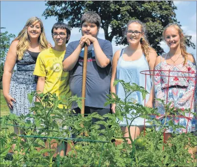  ?? ERIC MCCARTHY/JOURNAL PIONEER ?? Project co-ordinator Jenna MacDonald, left, joins participan­ts in a Good Food, Good Health – Westisle Garden Project on a tour of their garden. Participan­ts are Brendon Bulger, Jacob Gallant, Drew McInnis and Shannon Watters.