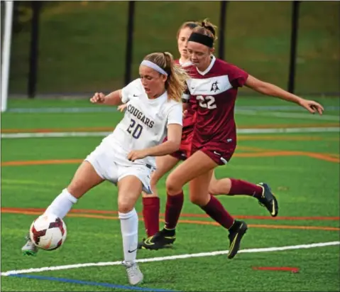  ?? PETE BANNAN — DIGITAL FIRST MEDIA ?? Downingtow­n East defenders Olivia Lawton clears the ball from Henderson’s Madelyn Weaverling on Wednesday.