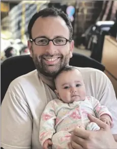  ?? ?? In this 2020 photo released by Eugene Brusilovsk­iy, Eugene holds his then-3-month-old daughter, Aya, in Philadelph­ia. EUGENE BRUSILOVSK­IY VIA AP