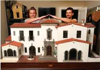  ?? Tribune News Service photos ?? ■ Matthew Mathiasen and his partner, artist Chris Toledo, with the structure Toledo has spent the past two years working on a grand home in miniature in their apartment in Los Angeles. The home is scaled down to 1/12th the size of a real home. At left, Toledo looks into the kitchen.