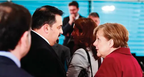  ??  ?? German Chancellor Angela Merkel talks with Aiman Mazyek, chairman of the Central Council of Muslims in Germany, on the sidelines of a recent meeting with representa­tives of refugee center organizati­ons in Berlin. (AFP)