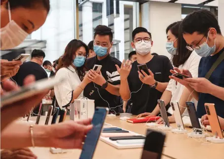  ?? AFP ?? Customers look at Huawei smartphone­s at a flagship store in Shanghai. Huawei plans to strengthen the brand in its core domestic market.