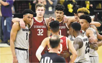  ?? Cliff Grassmick / Associated Press ?? Colorado and Stanford players gather at midcourt after Cardinal leading scorer Oscar da Silva slammed his head on the court in a scary collision with the Buffaloes’ big center, Evan Battey.
