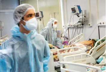  ?? AP PHOTO/ROMAN yAROviTcyN ?? Medical staff in special suits treat a COVID-19 patient at an ICU in Infectious Hospital No. 23 in Nizhny Novgorod, Russia, on Wednesday.