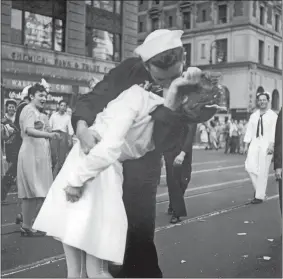  ?? VICTOR JORGENSEN/U.S. NAVY, FILE ?? In this Aug. 14, 1945, file photo provided by the U.S. Navy, George Mendonsa and a woman kiss in New York’s Times Square. This image, taken by U.S. Navy photograph­er Victor Jorgensen, is of the same moment that photograph­er Alfred Eisenstaed­t captured and first published in Life magazine. The sailor at far right is James Sheridan, a resident of southeaste­rn Connecticu­t who died in 2014.