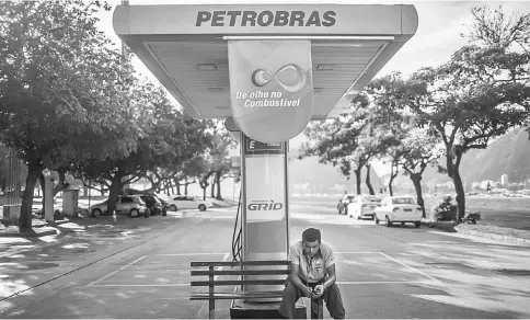  ??  ?? An employee sits on a bench at a Petrobras gas station in Rio de Janeiro on Oct 17, 2016. — WP-Bloomberg photos