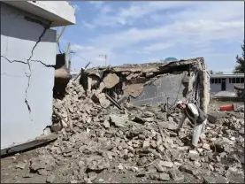  ?? (AP) ?? A man examines the spot where a car bomb detonated Monday at the intelligen­ce compound in Aybak, Afghanista­n.